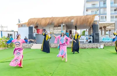 a group of people dancing on a grass field at Fanadir Bay Premier all inclusive resort in Hurghada