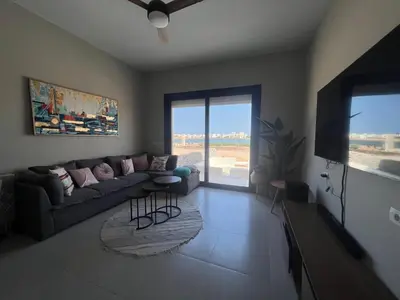 a living room with a couch and a flat screen tv at Cyan Luxe Retreat 3Bdr in Hurghada