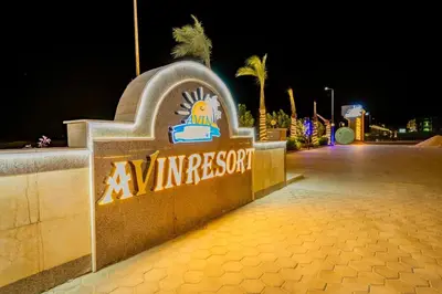 a sign for an entrance to a resort at night at Chic studio at a modern resort in Hurghada