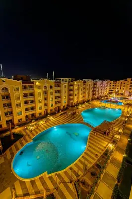 a row of swimming pools at night at Chic studio at a modern resort in Hurghada