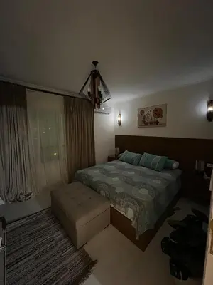 a bedroom with a bed and a couch in it at Chic studio at a modern resort in Hurghada