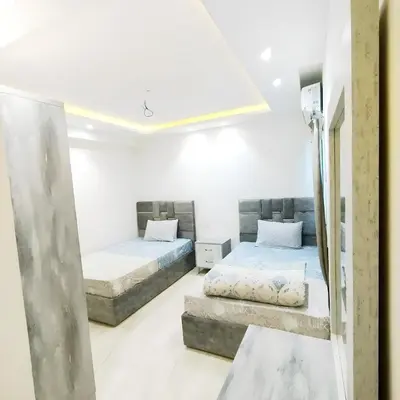 two beds in a room with white walls at Princess Beachfront Resort Hurghada in Hurghada