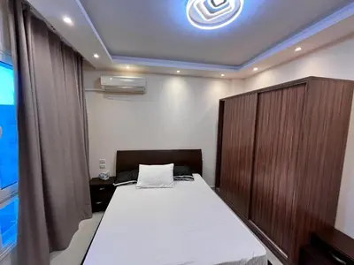 a bedroom with a bed with a wooden cabinet at Princess Beachfront Resort Hurghada in Hurghada