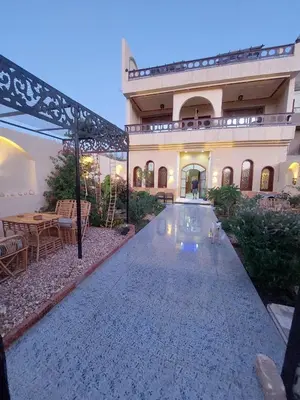 a large house with a swimming pool in front of it at Carter Guesthouse Luxor 4 in ‘Ezbet Abu Ḥabashi