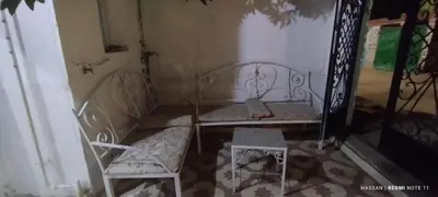 an empty room with two chairs and a table at the golden house in Luxor