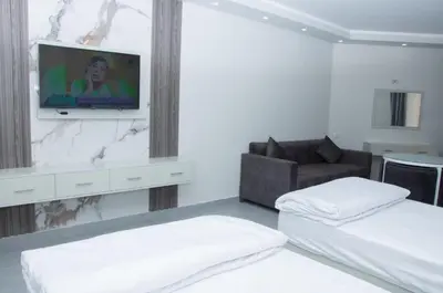 a room with two beds and a tv on a wall at Sea view studio in Hurghada