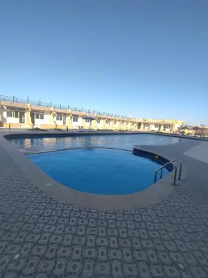 a large swimming pool with a ramp in front of a building at Luxuries Studios and apartments in Oasis Marina ,Hurghada in Hurghada