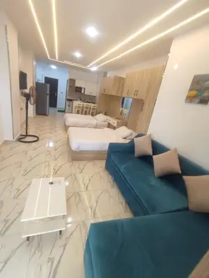 a living room with a blue couch and a bed at Luxuries Studios and apartments in Oasis Marina ,Hurghada in Hurghada