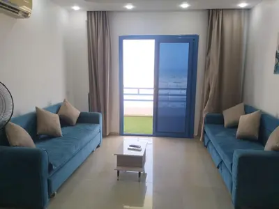 a living room with two blue couches and a table at Luxuries Studios and apartments in Oasis Marina ,Hurghada in Hurghada