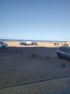 two cars parked in a parking lot next to a beach at Luxuries Studios and apartments in Oasis Marina ,Hurghada in Hurghada