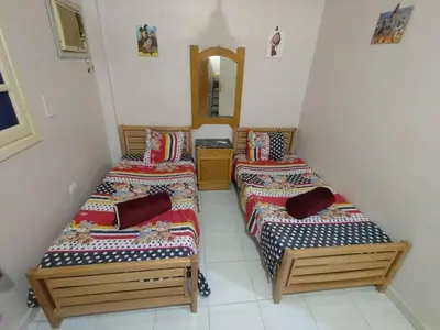 two beds in a room with a mirror at flat in Hurghada Sheraton Metro street in Hurghada