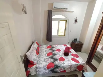 a small bedroom with a bed with red pillows at flat in Hurghada Sheraton Metro street in Hurghada