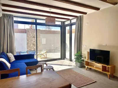 a living room with a blue couch and a tv at Gouna Retreat with Private Pool in Bali in Hurghada