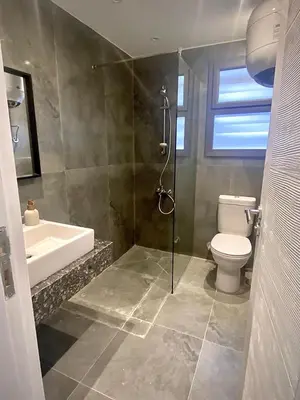 a bathroom with a shower and a toilet and a sink at Gouna Retreat with Private Pool in Bali in Hurghada