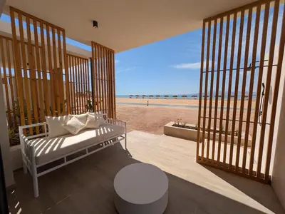 a room with a bed and a view of the beach at Beachfront Somabay Cabana Steps From Sea & Pool in Hurghada