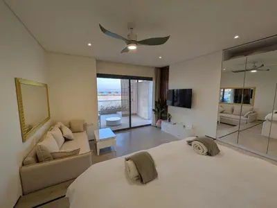 a bedroom with a large white bed and a couch at Beachfront Somabay Cabana Steps From Sea & Pool in Hurghada
