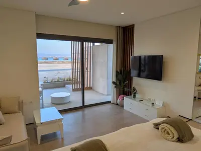 a bedroom with a bed and a view of a beach at Beachfront Somabay Cabana Steps From Sea & Pool in Hurghada