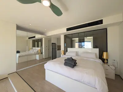 a bedroom with a large white bed with a ceiling fan at Beachfront Somabay Cabana Steps From Sea & Pool in Hurghada