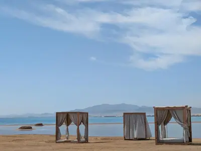two chairs and a table on a beach at Beachfront Somabay Cabana Steps From Sea & Pool in Hurghada