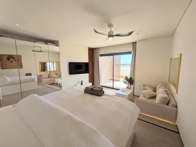a large white bedroom with a large bed and a couch at Beachfront Somabay Cabana Steps From Sea & Pool in Hurghada