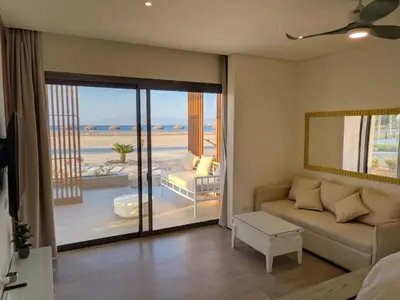 a living room with a couch and a view of the beach at Beachfront Somabay Cabana Steps From Sea & Pool in Hurghada