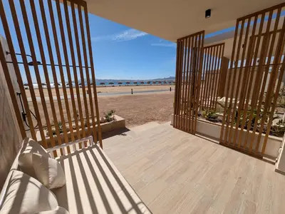 an open door to a porch with a view of the beach at Beachfront Somabay Cabana Steps From Sea & Pool in Hurghada