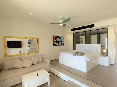 a bedroom with a white bed and a couch at Beachfront Somabay Cabana Steps From Sea & Pool in Hurghada