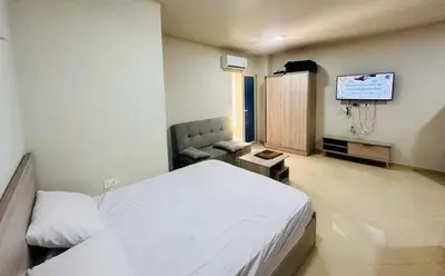 a bedroom with a bed and a flat screen tv at Zuni in Hurghada