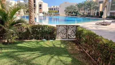a gate in the grass next to a swimming pool at Mangroovy Gouna Beach and pool in Hurghada