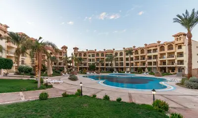 an apartment complex with a swimming pool and palm trees at Al Saraya Sahl Hasheesh by Peaks One Bedroom Apartment With Pool View B405&A410 in Hurghada