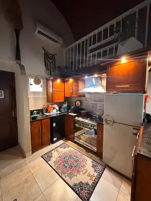 a kitchen with wooden cabinets and a white refrigerator at Luxury cozy apartment in Hurghada