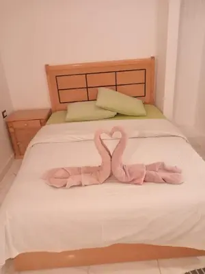 two pink flamingos sitting on top of a bed at Talamermaid in Hurghada