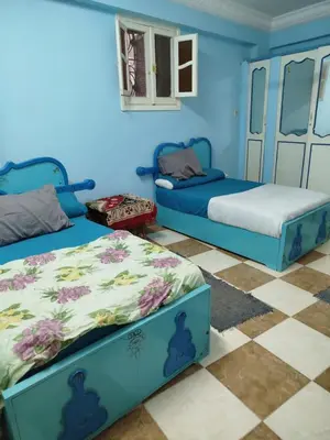 two beds in a room with blue walls at Luna Nile in Aswan
