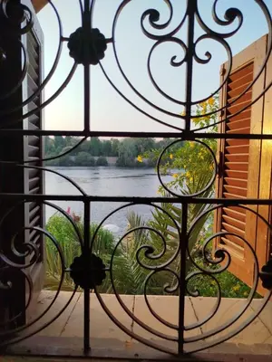 a view of a river from a wrought iron gate at Luna Nile in Aswan