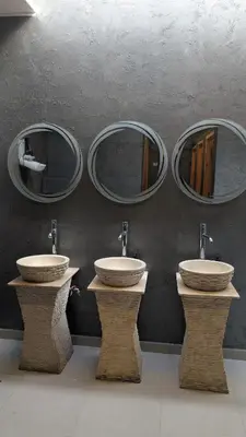 three sinks in a bathroom with three mirrors at Hostify Hostel and Rooftop in Hurghada