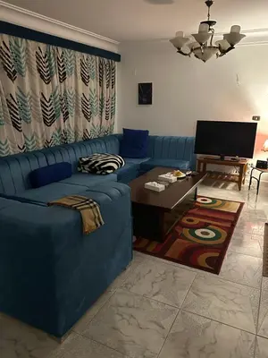 a living room with a blue couch and a table at Paradise Villa in Hurghada