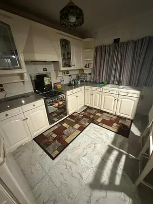 a kitchen with white cabinets and a tile floor at Paradise Villa in Hurghada