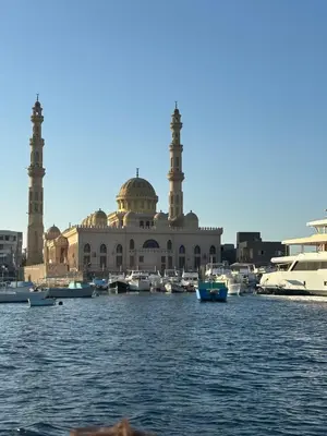 a building with two mosques and boats in the water at Paradise Villa in Hurghada