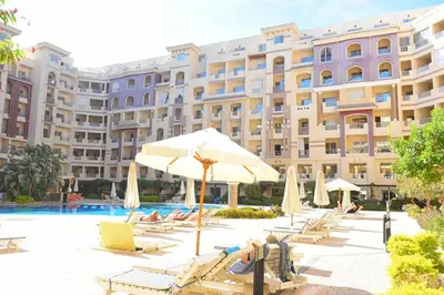 a hotel with chairs and umbrellas and a pool at كمباوند فلورنزا خمسين Florenza Khamsin in Hurghada