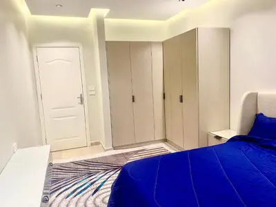 a bedroom with a blue bed and a white door at كمباوند فلورنزا خمسين Florenza Khamsin in Hurghada