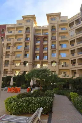 a large building with tables and chairs in front of it at كمباوند فلورنزا خمسين Florenza Khamsin in Hurghada