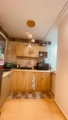 a kitchen with wooden cabinets and a counter top at Chill & Cozy Stay in Hurghada