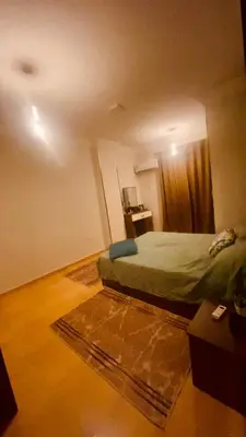 a bedroom with a bed and a rug in a room at Chill & Cozy Stay in Hurghada