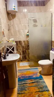 a bathroom with a shower and a sink and a toilet at Chill & Cozy Stay in Hurghada