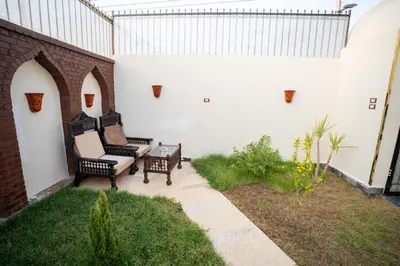 a patio with two chairs and a table at The Village House with Private Garden - Four Bedroom Nubian Home on Luxor West Bank in Luxor