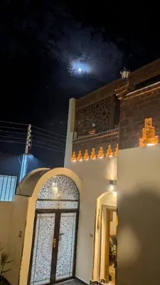 a building with a door with a moon in the background at The Village House with Private Garden - Four Bedroom Nubian Home on Luxor West Bank in Luxor