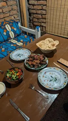 a wooden table with plates of food on it at The Village House with Private Garden - Four Bedroom Nubian Home on Luxor West Bank in Luxor