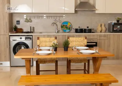 a wooden table with chairs in a kitchen at Mangroovy Retreat Smart home in Hurghada