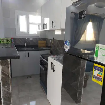 a kitchen with white cabinets and a stove top oven at Veranda SH in Hurghada