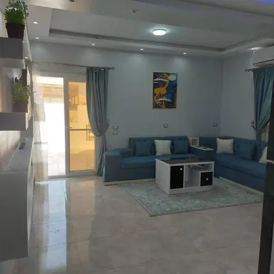a living room with blue couches and a table at Veranda SH in Hurghada